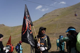Climbing Tochal Peak with the flag of Imam Hossein (AS)